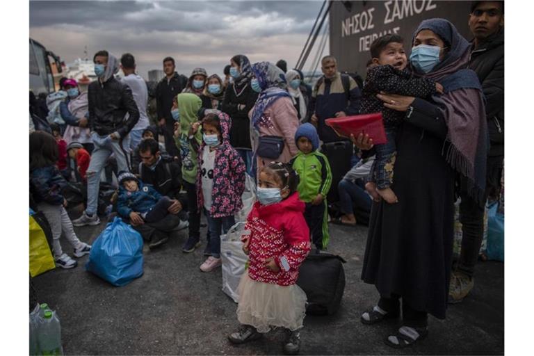 Flüchtlinge aus dem Lager Moria auf Lesbos gehen im Hafen von Piräus bei Athen an Land. Die Asylreform kommt seit Jahren kaum voran, weil die EU-Staaten vor allem bei der Verteilung von Schutzsuchenden völlig zerstritten sind. Foto: Angelos Tzortzinis/dpa/dpa