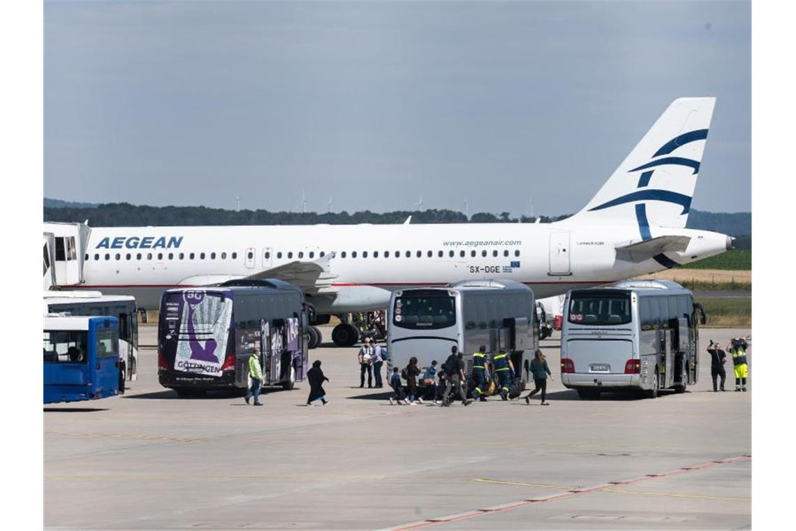 Flüchtlinge aus griechischen Flüchtlingslagern steigen aus dem Flugzeug am Flughafen Kassel-Calden. Foto: Swen Pförtner/dpa