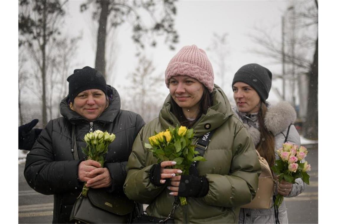 Flüchtlinge bekommen an der rumänisch-ukrainischen Grenze in Siret anlässlich des Internationalen Frauentags Blumen. Foto: Andreea Alexandru/AP/dpa