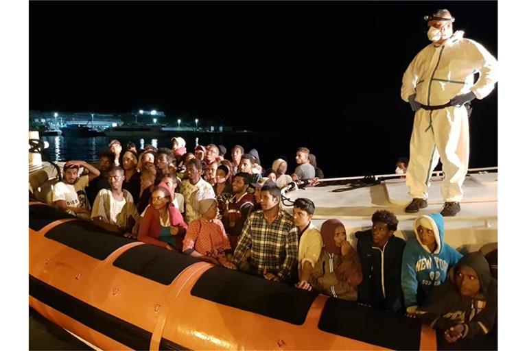 Flüchtlinge bereiten sich darauf vor, bei ihrer Ankunft im Hafen von Lampedusa aus einem Beiboot zu steigen (Archiv). Foto: Elio Desiderio/ANSA/dpa