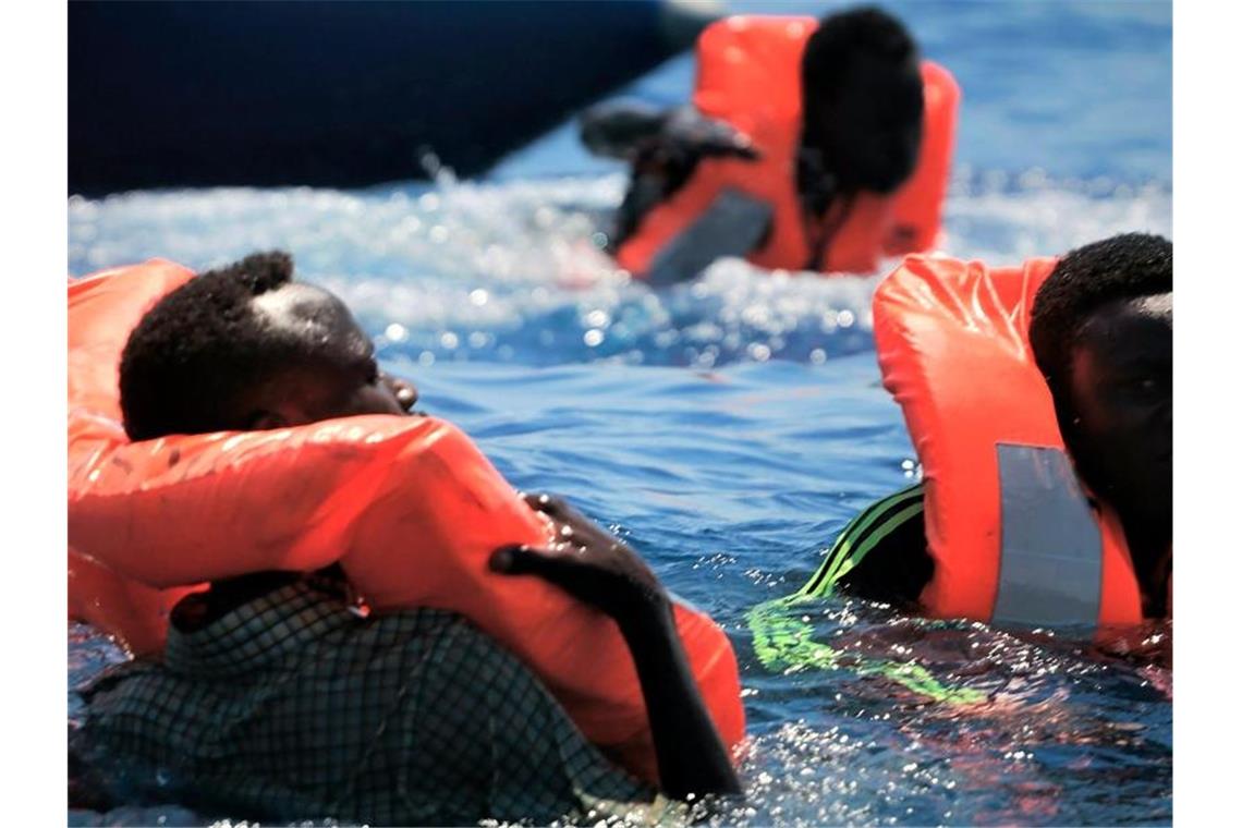 Flüchtlinge schwimmen mit Rettungswesten im Meer, bevor sie vom Rettungsschiff „Ocean Viking“ aufgenommen werden. Foto: Hannah Wallace Bowman/MSF/Sos Méditerranée