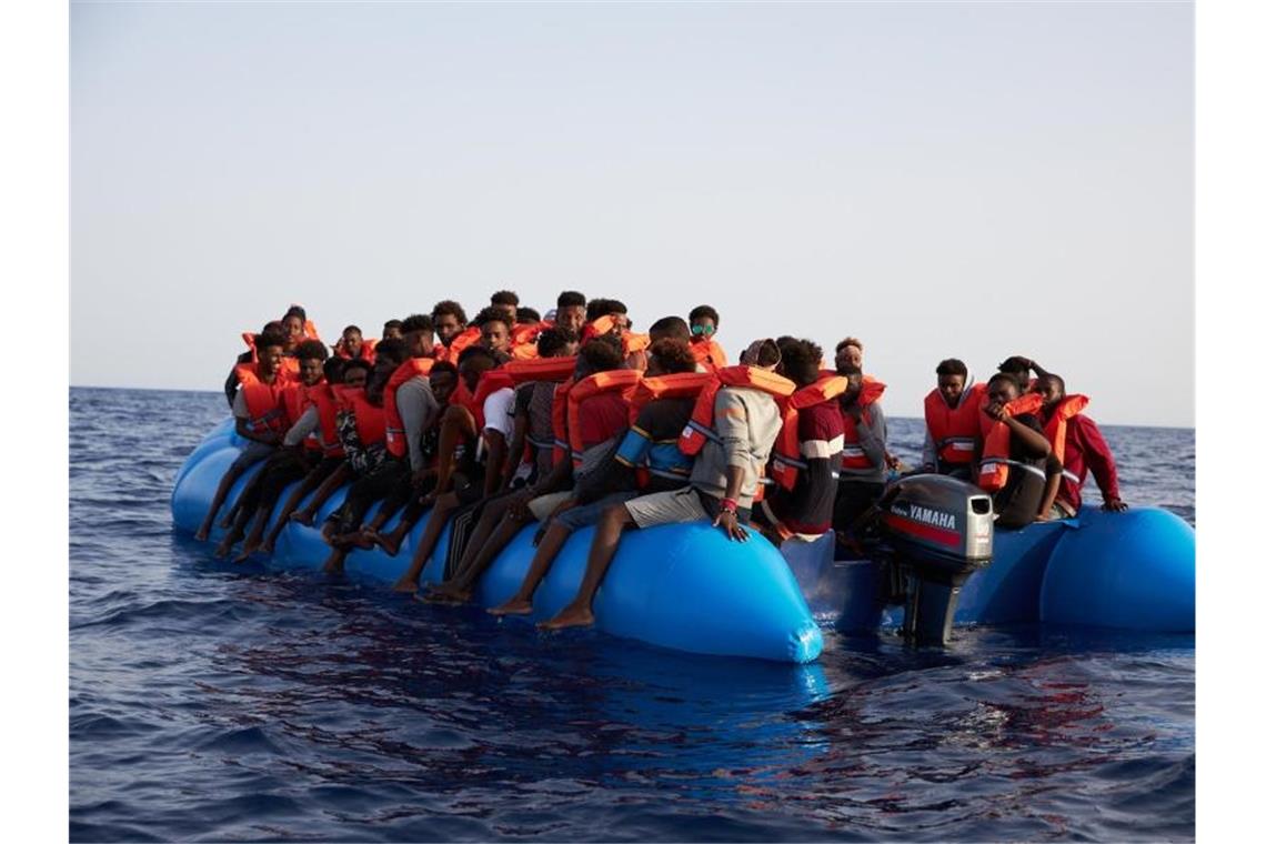 Flüchtlinge sitzen vor der Küste von Libyen in einem Schlauchboot, bevor sie vom Hilfsschiff „Alan Kurdi“ gerettet werden. Foto: Fabian Heinz/Sea-Eye