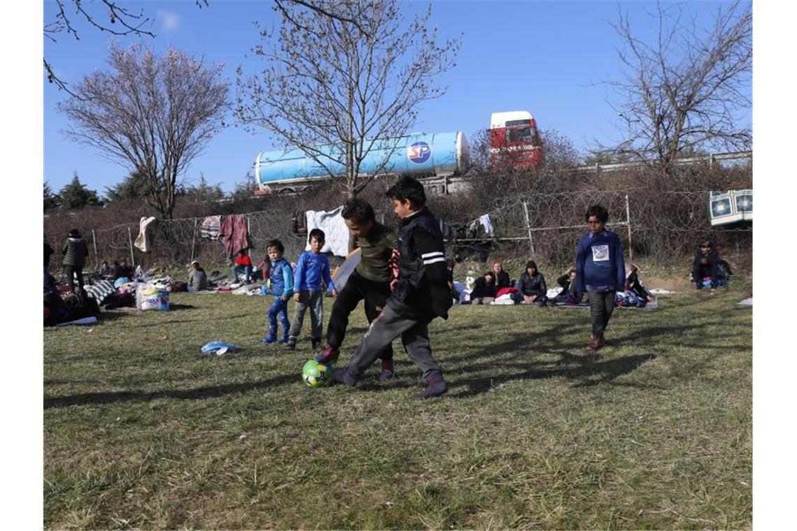 Deutschland nimmt geflüchtete Kinder auf Flüchtlingskinder spielen auf türkischer Seite vor dem Grenzzaun zu Griechenland. Foto: Darko Bandic/AP/dpa