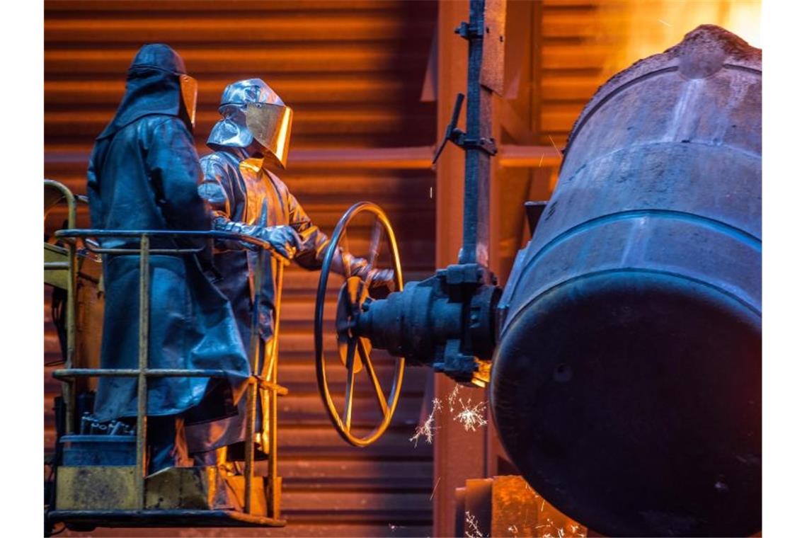 Flüssiges Eisen mit einer Temperatur von 1.400 Grad gießen Arbeiter in der Eisengießerei in vorbereitete Formen. Foto: Jens Büttner/dpa-Zentralbild/dpa