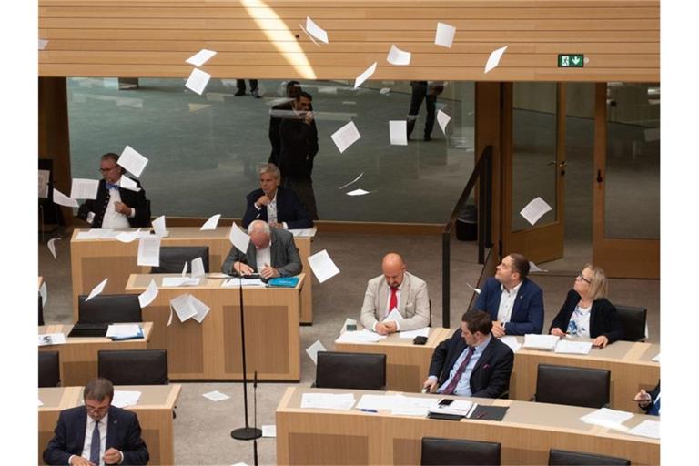 Flugblätter jugendlicher Klimaschützer fliegen während einer Plenarsitzung von der Besuchertribüne in den Plenarsaal. Foto: Marijan Murat