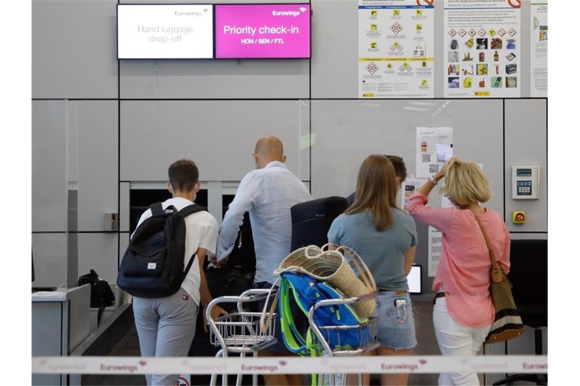 Pauschalreisen: Touristik organisiert Sicherungsfonds selbst Fluggäste geben im Abflugbereich des Flughafens von Palma de Mallorca am Eurowings-Schalter ihre Koffer ab. Foto: Clara Margais/dpa
