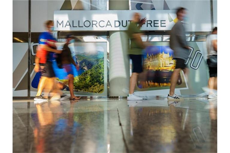 Fluggäste gehen durch den Flughafen in Palma de Mallorca. Foto: Andreas Arnold/dpa
