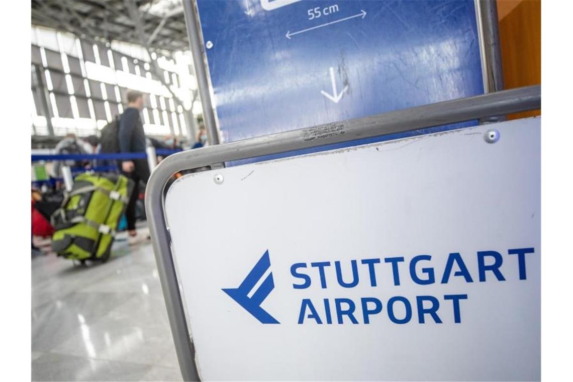 Fluggäste gehen mit ihrem Gepäck zu Check-In-Schaltern am Flughafen Stuttgart. Foto: Christoph Schmidt/dpa