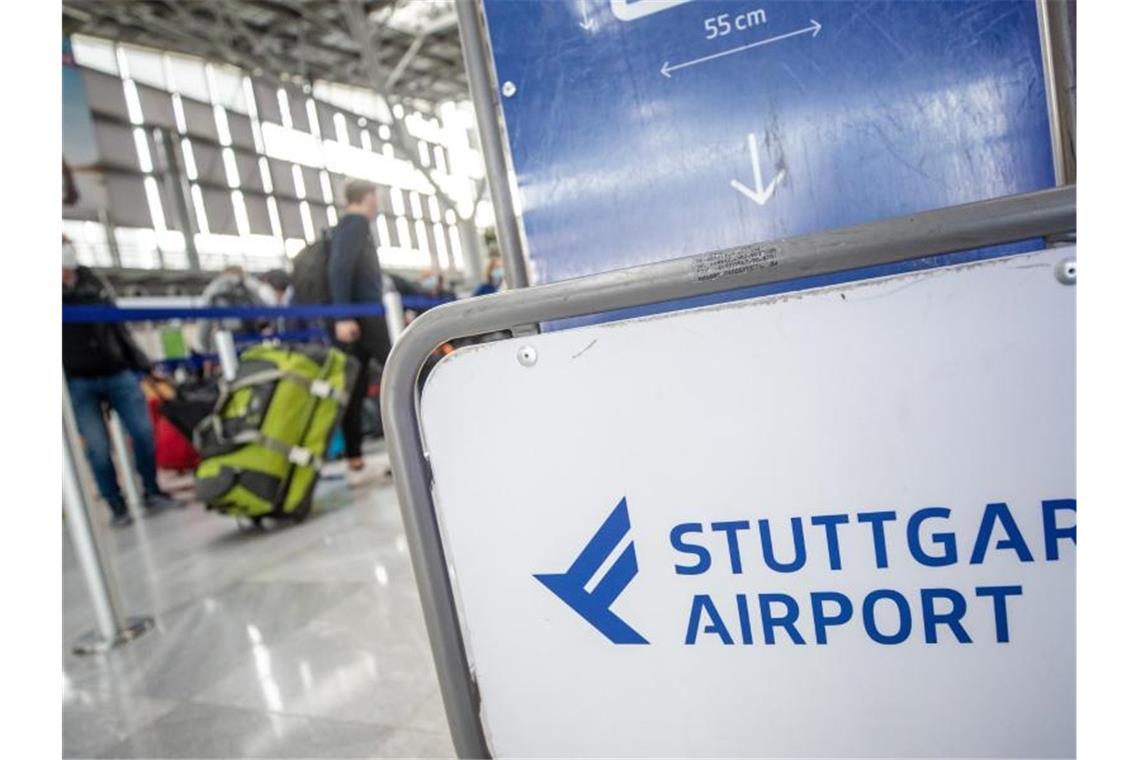 Fluggäste gehen mit ihrem Gepäck zu Check-In-Schaltern am Flughafen Stuttgart. Foto: Christoph Schmidt/dpa/Symbolbild