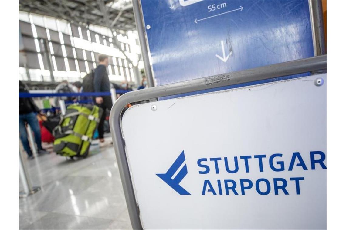 Flugpassagiere müssen mit starken Einschränkungen rechnen Fluggäste gehen mit ihrem Gepäck zu Check-In-Schaltern am Flughafen Stuttgart. Foto: Christoph Schmidt/dpa/Archivbild