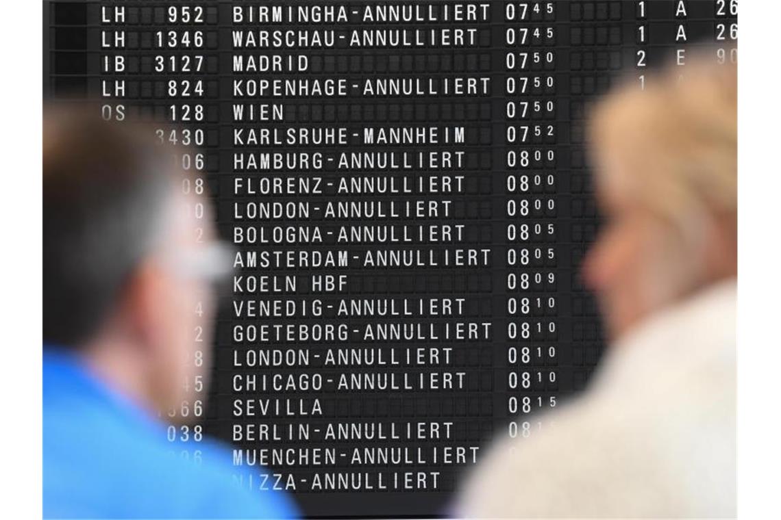 Nach Flugchaos-Sommer sinkt Zahl der Schlichtungsfälle Fluggäste stehen im Terminal 1 des Frankfurter Flughafens vor einer Anzeigetafel, auf der annullierte Flüge angezeigt sind. Foto: Arne Dedert