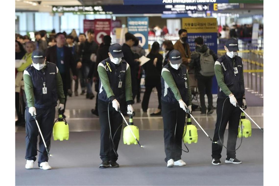 Flughafenpersonal sprüht im südkoreanischen Flughafen Incheon International eine keimtötende Lösung. Foto: Suh Myung-Geon/Yonhap/dpa