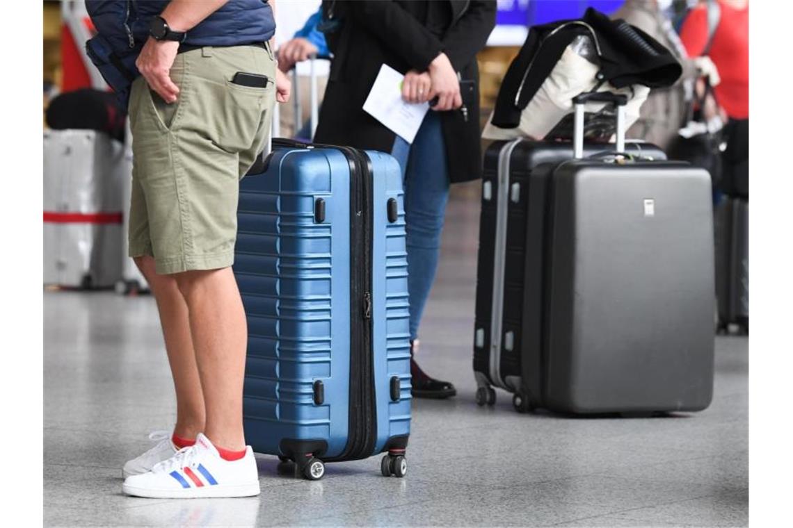 Flugreisende stehen in Terminal 1 des Frankfurter Flughafens am Check-in-Schalter an. Reiserückkehrer aus Risikogebieten sollen sich an Flughäfen verpflichtend auf das Coronavirus testen lassen. Foto: Arne Dedert/dpa