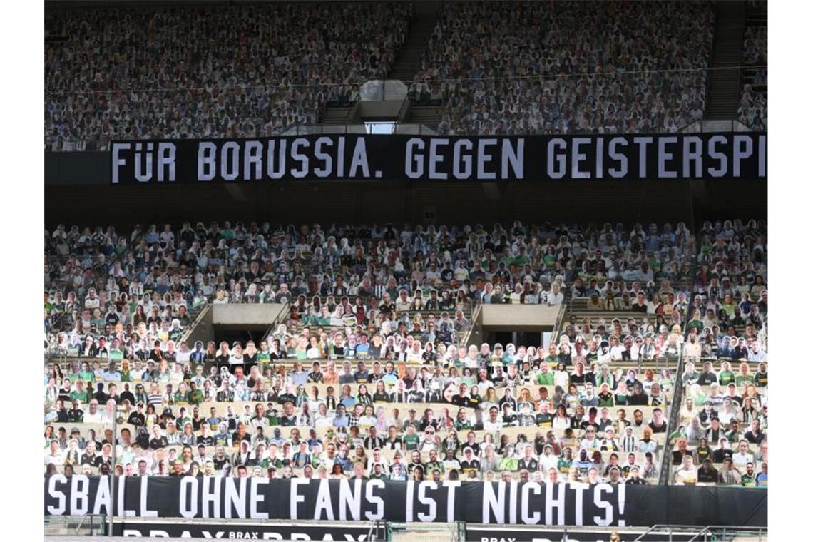 Fotos von Fans sind auf Pappfiguren auf der Tribüne des Borussia-Parks aufgestellt. Foto: Ina Fassbender/AFP-Pool/dpa