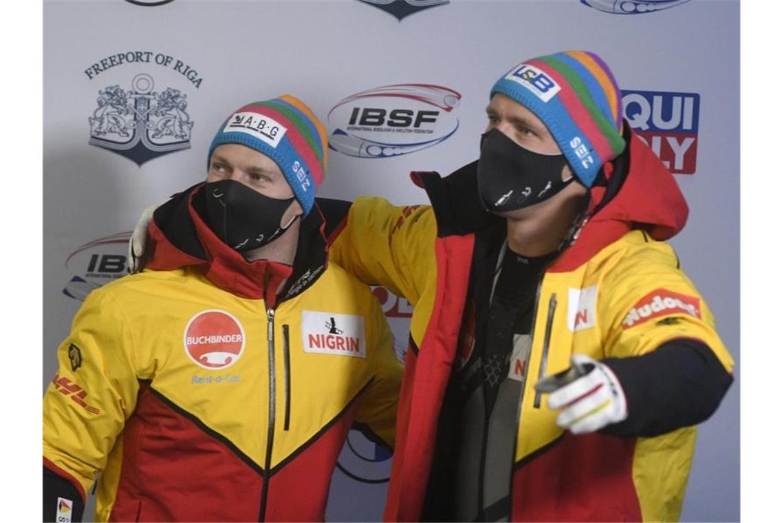 Francesco Friedrich und Thorsten Margis bei der Siegerehrung. Foto: Roman Koksarov/AP/dpa