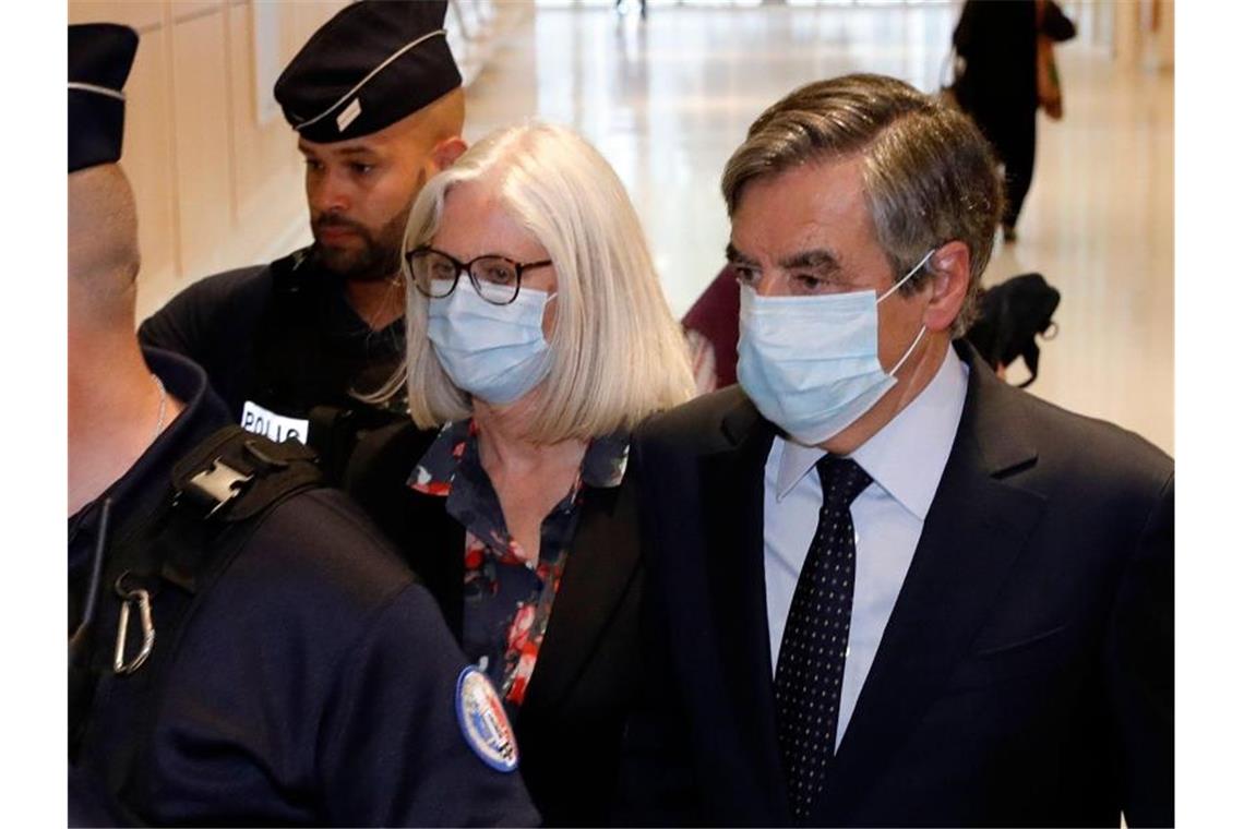 Francois Fillon (r), ehemaliger Premierminister von Frankreich, und seine Frau Penelope Fillon (2.v.r) beim Verlassen des Gerichtsgebäudes. Foto: Thomas Samson/AFP/dpa