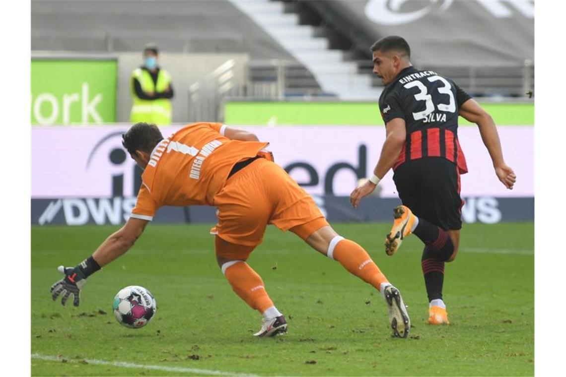 Frankfurts Andre Silva (r) versucht den Ball per Hacke an Bielefelds Torwart Stefan Ortega Moreno ins Tor zu schießen. Foto: Arne Dedert/dpa