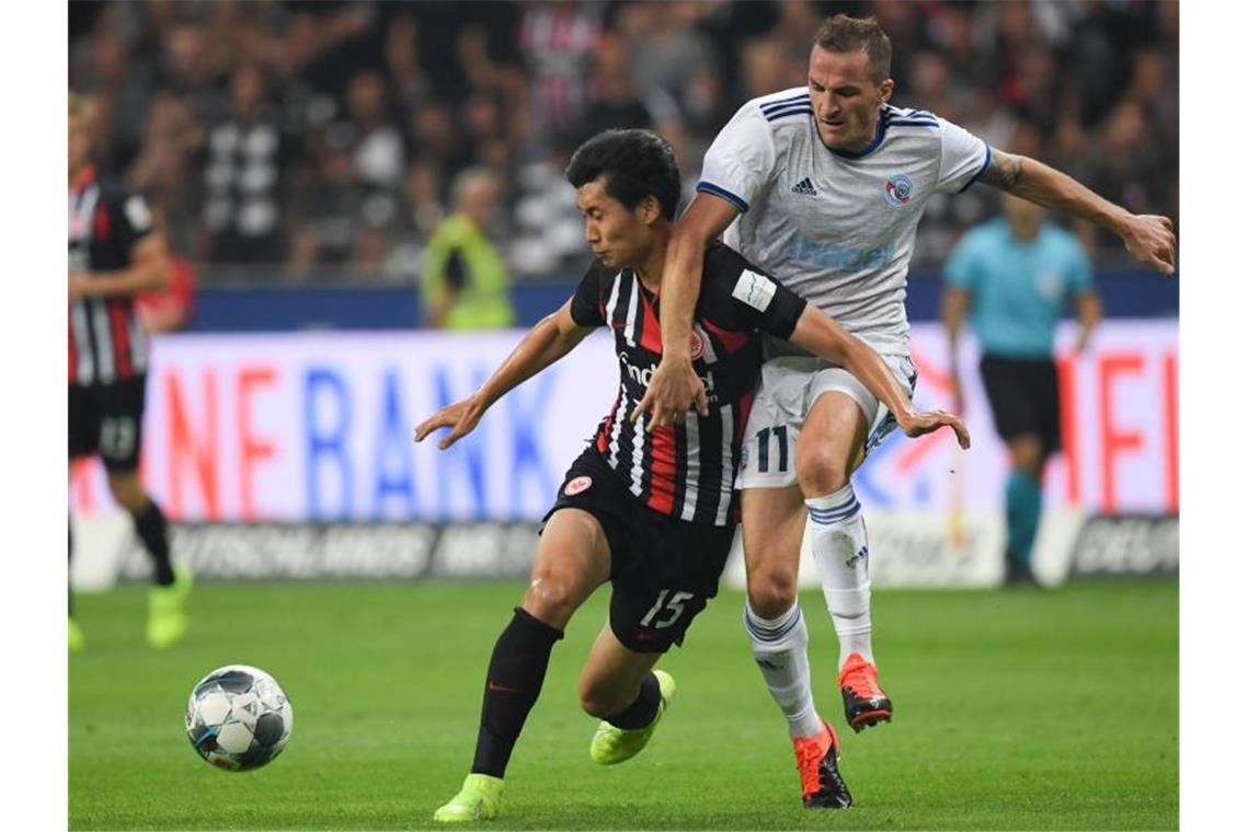 „Fantastische Nacht“: Eintracht in der Gruppenphase Frankfurts Daichi Kamada (l) setzt sich gegen den Dimitri Lienard von Racing Straßburg beim Kampf um den Ball durch. Foto: Arne Dedert