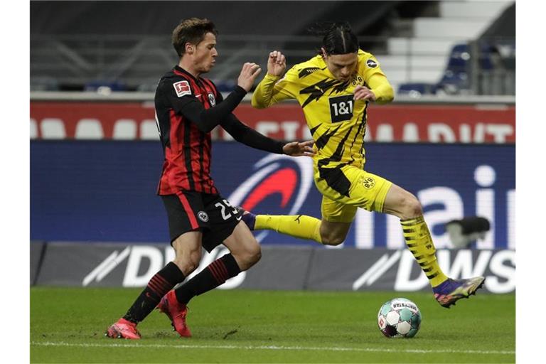 Frankfurts Erik Durm (l) und Dortmunds Nico Schulz kämpfen um den Ball. Foto: Michael Probst/AP POOL/dpa