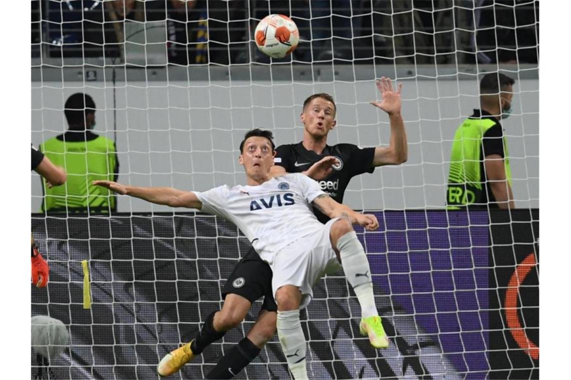 Frankfurts Erik Durm (r) und Istanbuls Mesut Özil kämpfen um den Ball. Foto: Arne Dedert/dpa