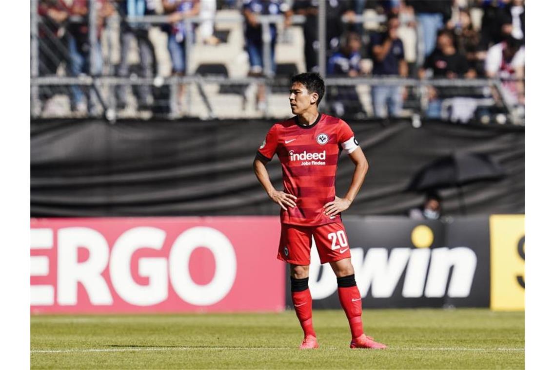 Frankfurt fliegt raus - Wolfsburg droht nach Panne das Aus Frankfurts Makoto Hasebe steht nach dem Tor zum 0:2 fassungslos auf dem Spielfeld. Foto: Uwe Anspach/dpa