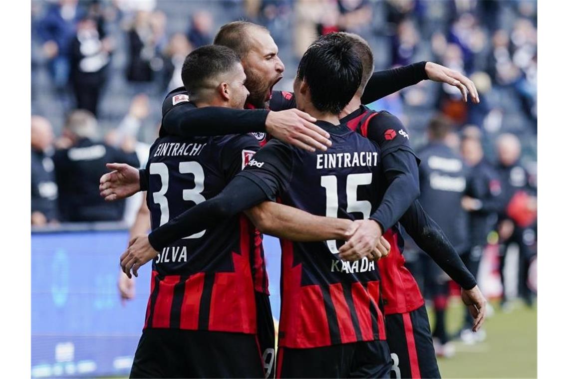 Frankfurts Torschütze Bas Dost (2.v.l.) jubelt mit Mannschaftskollegen über das Tor zum 2:1. Foto: Uwe Anspach/dpa