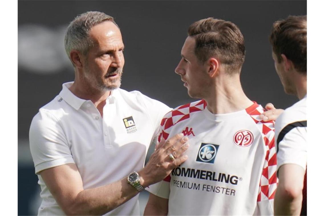 Frankfurts Trainer Adi Hütter (l) unterhält sich nach Spielende mit dem Mainzer Dominik Kohr. Foto: Thomas Frey/dpa