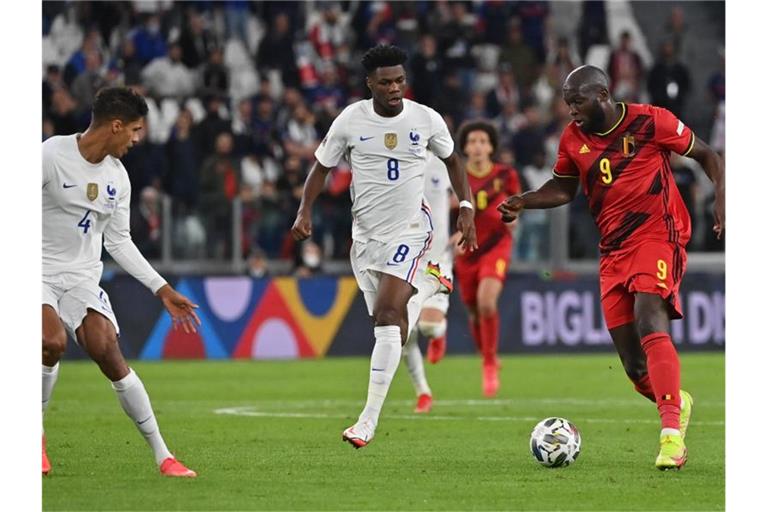 Frankreichs Aurelien Tchouameni (M) und Belgiens Romelu Lukaku (r) kämpfen um den Ball. Foto: Dirk Waem/BELGA/dpa