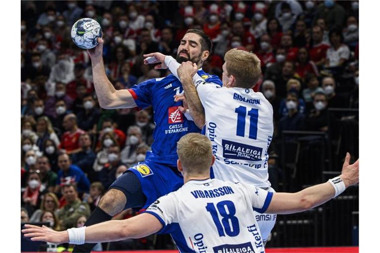 Frankreichs Nikola Karabatic setzt gegen die Isländer Ymir Gislason (r) und Ellidi Vidarsson (18)zum Wurf an. Foto: Zsolt Szigetvary/MTI/AP/dpa