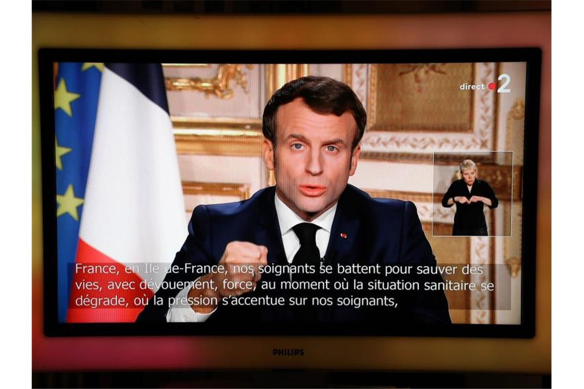 Frankreich im „Gesundheitskrieg“ gegen Corona Frankreichs Präsident Emmanuel Macron hält im Fernsehen eine Ansprache: „Der Feind ist da, unsichtbar - und er rückt vor.“. Foto: Ludovic Marin/AFP/dpa