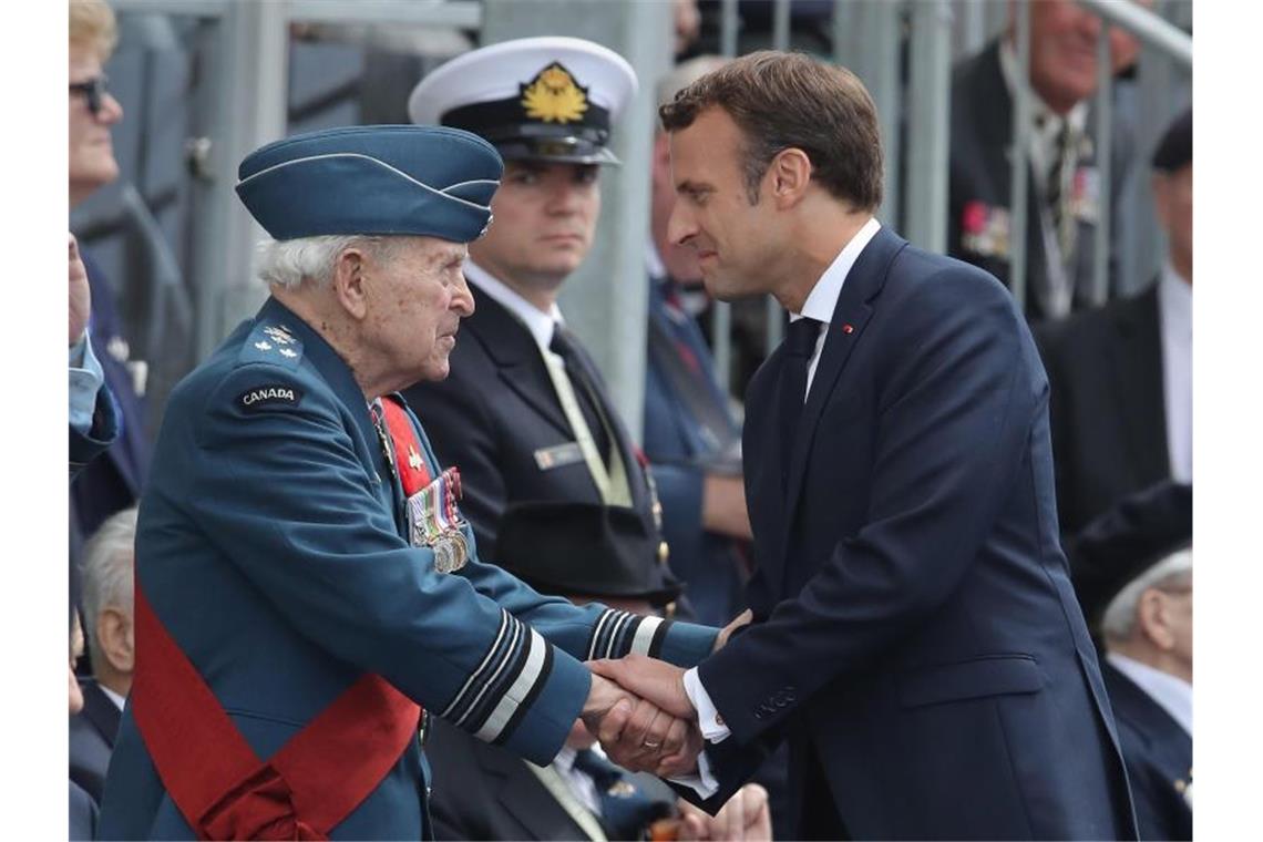 Staats- und Regierungschefs gedenken D-Day in Portsmouth Frankreichs Präsident Emmanuel Macron im Gespräch mit einem Veteranen. Foto: Andrew Matthews/PA Wire