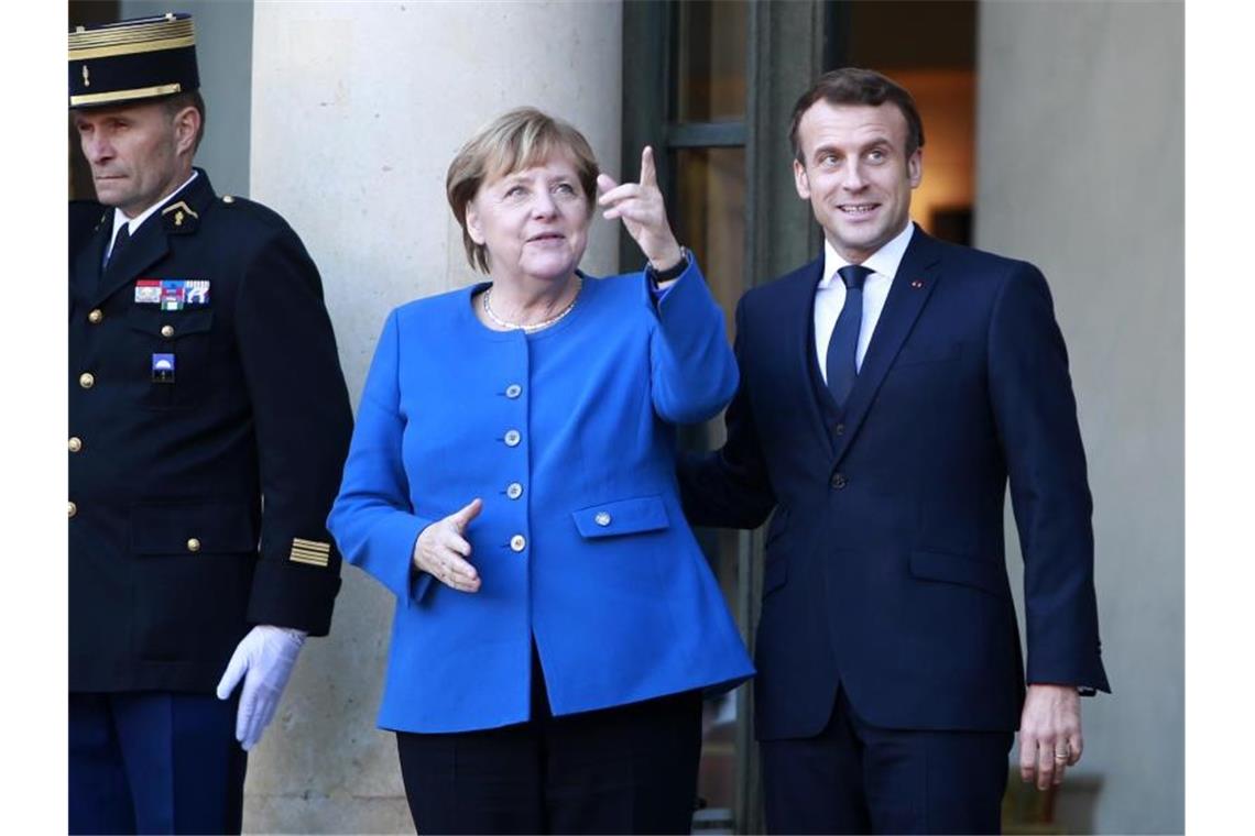Frankreichs Präsident Emmanuel Macron (r.), begrüßt Angela Merkel Pariser Elysée-Palast. Foto: Rafael Yaghobzadeh/AP/dpa