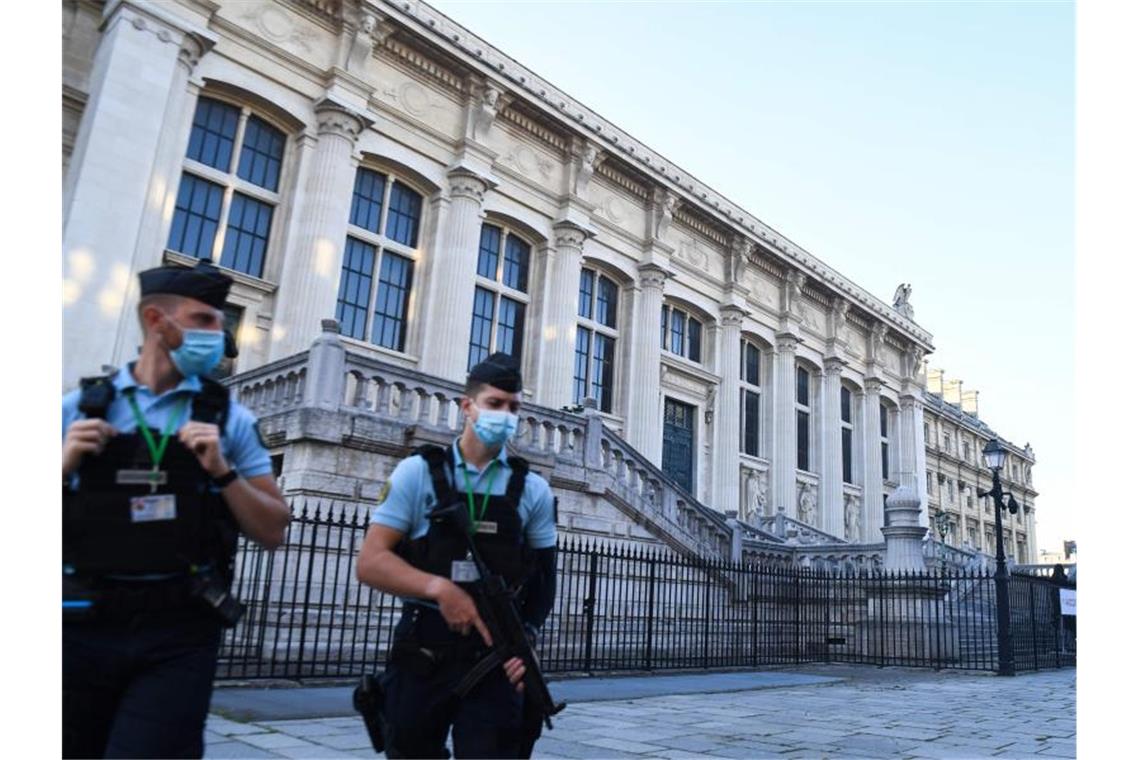Französische Gendarmen patrouillieren vor Beginn des Prozesses vor dem Justizpalast, dem Pariser Gerichtsgebäude. Foto: Alain Jocard/AFP/dpa