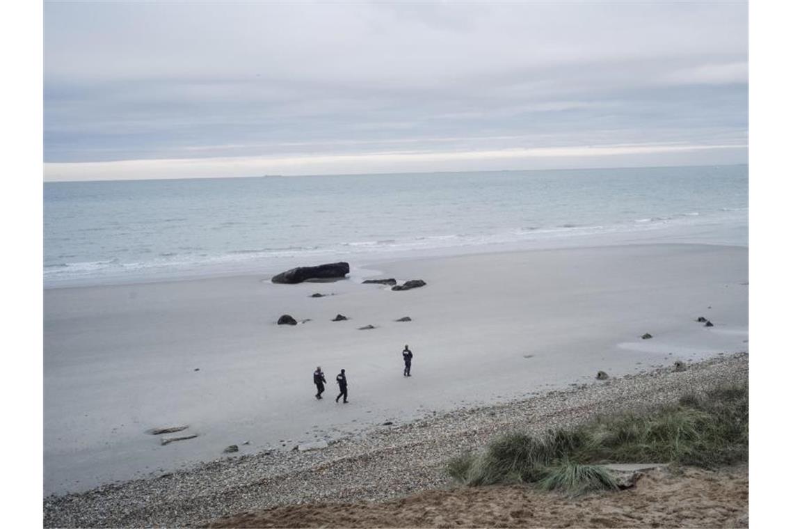 Französische Polizisten patrouillieren am Strand auf der Suche nach Migranten. Foto: Louis Witter/AP/dpa