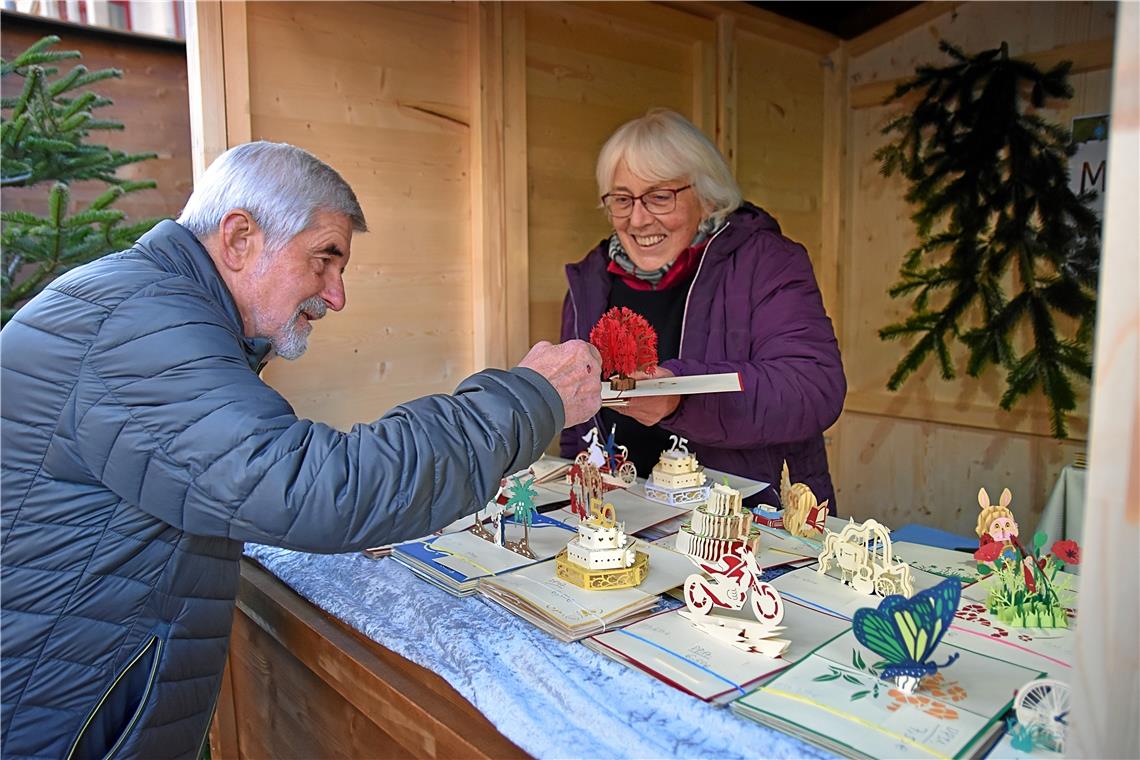 Frau Wilstermann zeigt einem Besucher die Papierkunst. 