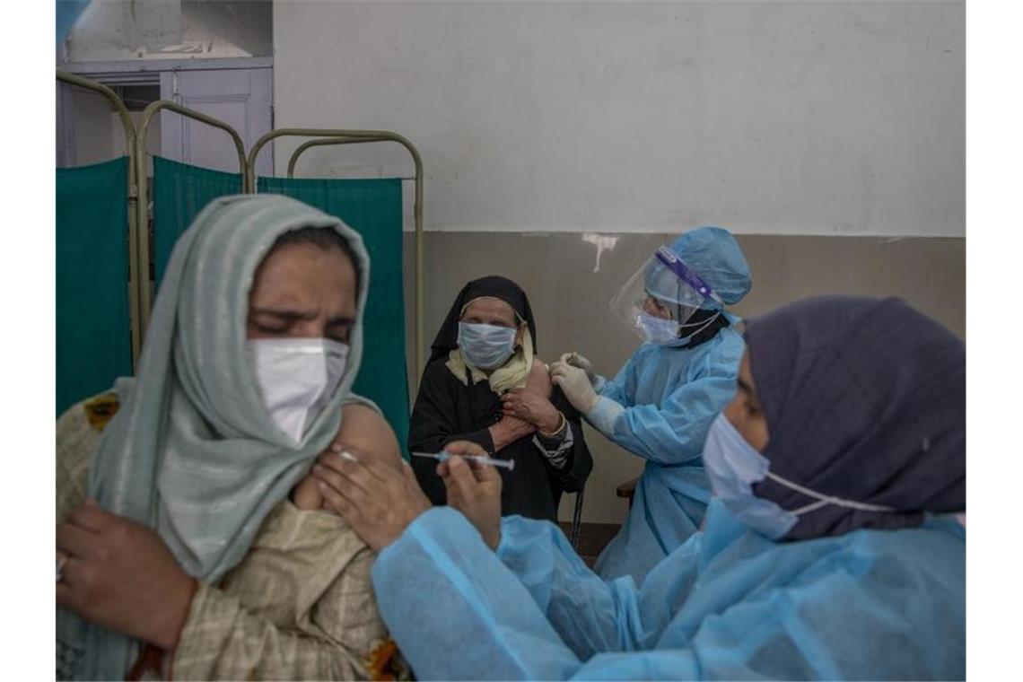 Frauen erhalten im nordinischen Srinagar eine Corona-Impfung. In dem Riesenland haben bislang weniger als zehn Prozent der Menschen mindestens eine Impfdosis erhalten. Foto: Dar Yasin/AP/dpa