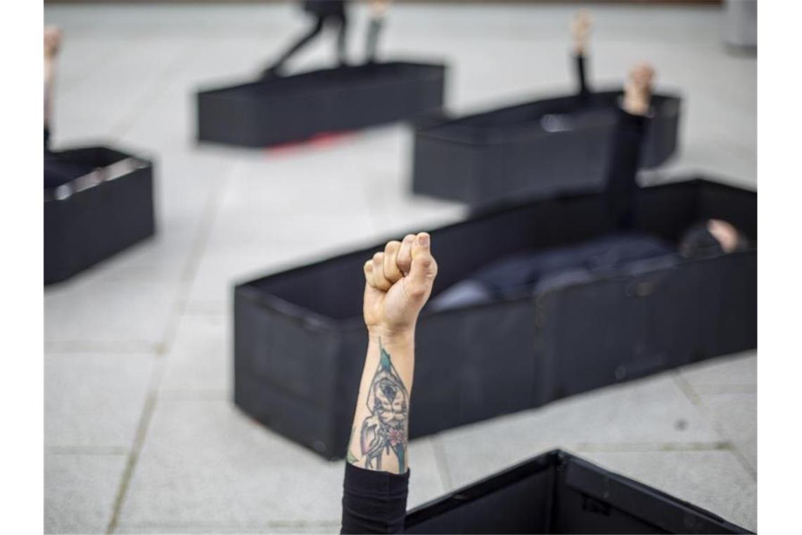 Gewalt gegen Frauen - Statistik erfasst nur die Spitze Frauen heben ihre Fäuste, während sie bei einer Demonstration im Vorfeld des Internationalen Frauentages vor dem Bundesgericht von Tel Aviv in Särgen liegen. Die Särge repräsentieren Frauen, die durch häusliche Gewalt getötet wurden. Foto: Ariel Schalit/AP/dpa