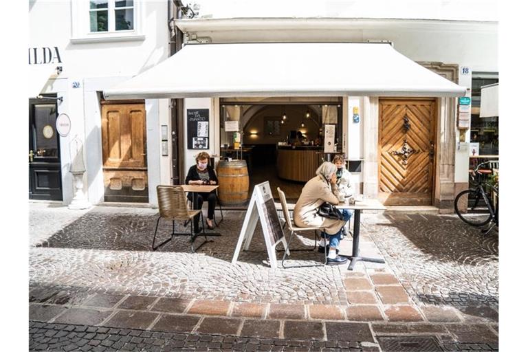 Frauen mit Mundschutz trinken Kaffee vor einer Bar in Bozen. Foto: Matteo Groppo/LaPresse via ZUMA Press/dpa