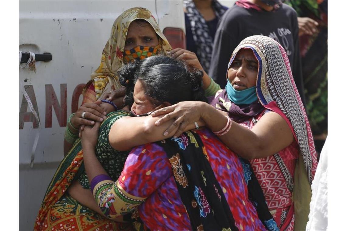 Frauen trauern in Ahmedabad um einen an Covid-19 gestorbenen Angehörigen. Foto: Ajit Solanki/AP/dpa