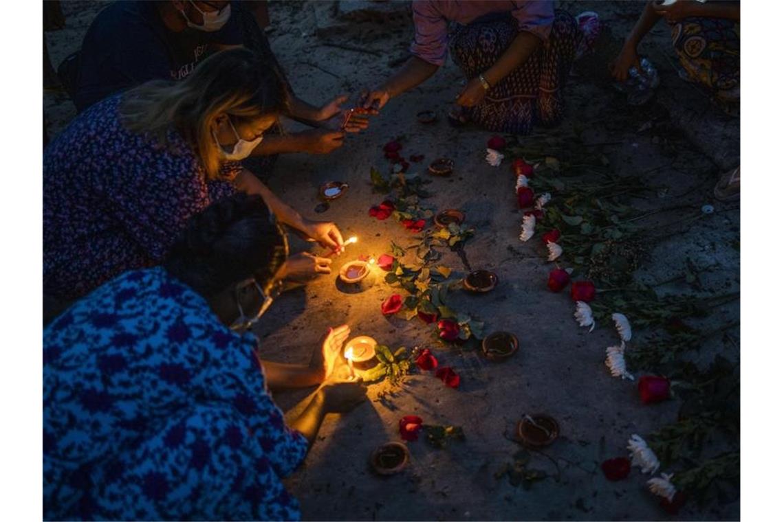 Frauen zünden während einer Zeremonie in Yangon Kerzen an, um den Opfern zu gedenken, die bei Massendemonstrationen gegen die Junta getötet wurden. Foto: Uncredited/AP/dpa