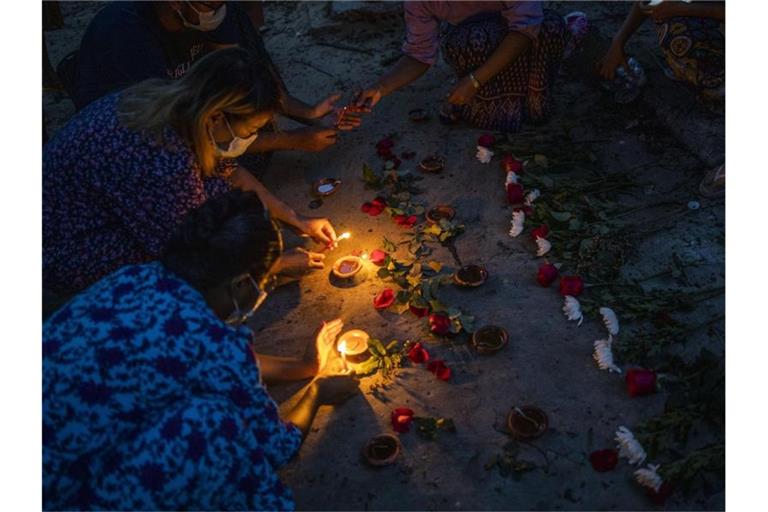 Frauen zünden während einer Zeremonie in Yangon Kerzen an, um den Opfern zu gedenken, die bei Massendemonstrationen gegen die Junta getötet wurden. Foto: Uncredited/AP/dpa