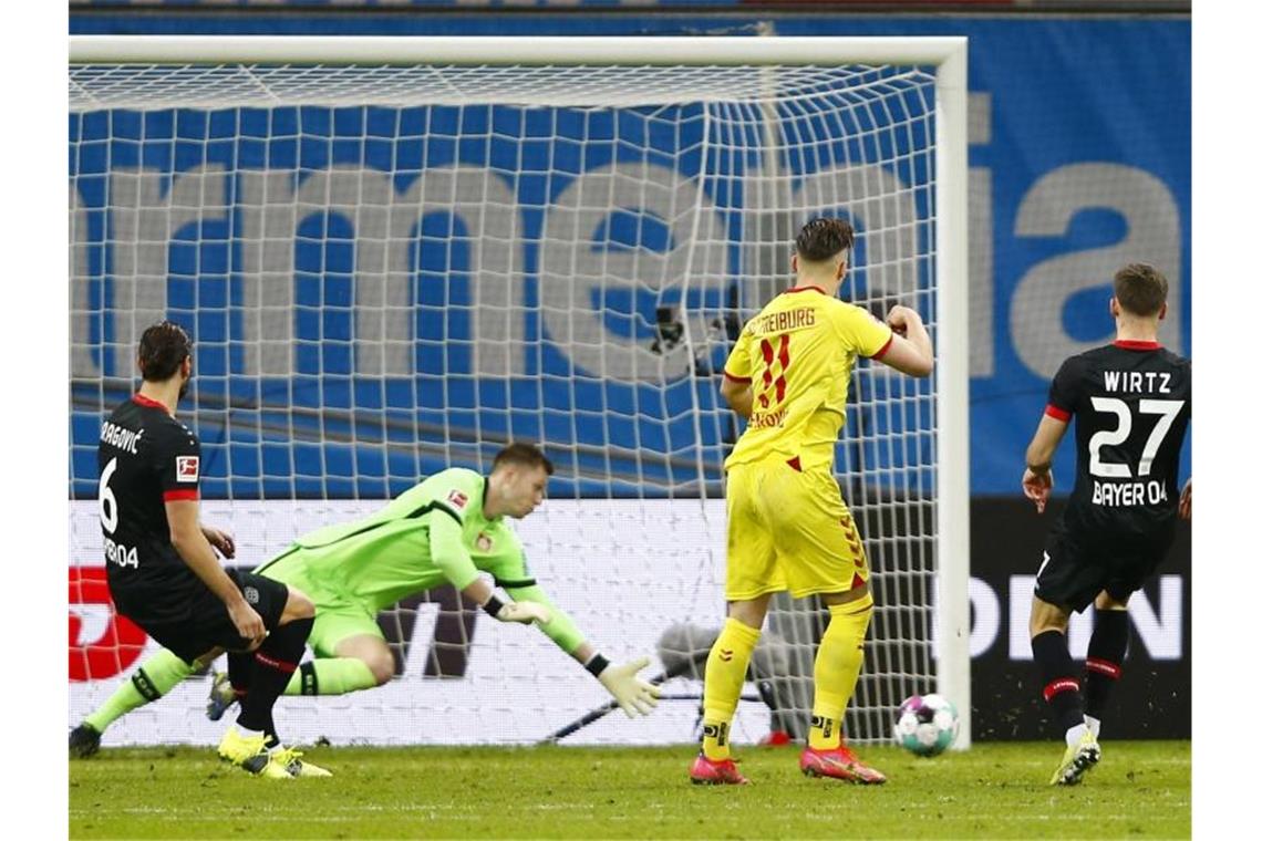 Freiburgs Ermedin Demirovic (2.vr) erzielt das Tor zum 1:0 gegen Leverkusens Torwart Lennart Grill. Foto: Thilo Schmuelgen/Reuters/Pool/dpa