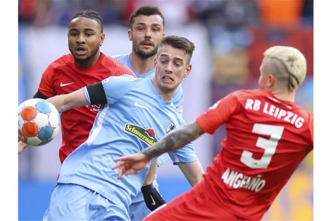 Remis im Spitzenspiel in München - Stuttgart gewinnt Freiburgs Janik Haberer und Angelino von RB Leipzig im Zweikampf um den Ball. Foto: Jan Woitas/dpa-Zentralbild/dpa
