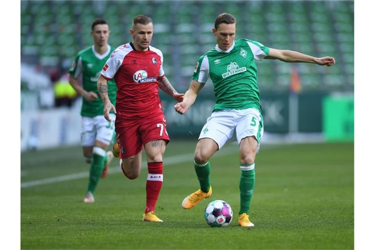Freiburgs Jonathan Schmid und Bremens Ludwig Augustinsson (l-r.) im Zweikampf um den Ball. Foto: Carmen Jaspersen/dpa