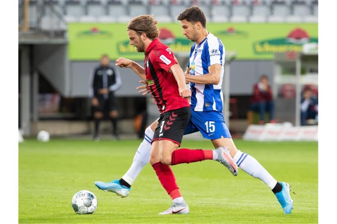 Freiburgs Lucas Höler und Berlins Marko Grujic (l-r.) im Duell um den Ball. Foto: Tom Weller/dpa pool/dpa