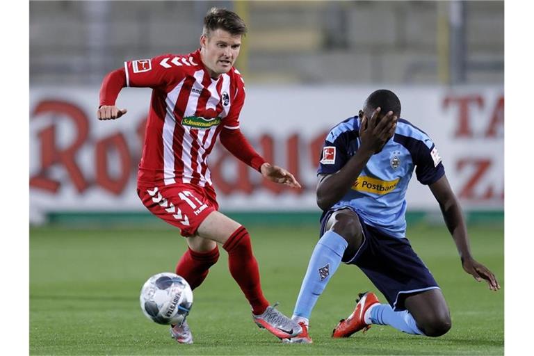 Freiburgs Lukas Kübler (l) und Mönchengladbachs Marcus Thuram in Aktion. Foto: Ronald Wittek/epa/Pool/dpa/Archivbild