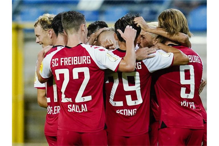 Freiburgs Mannschaft jubelt über das Tor zum 1:2. Foto: Uwe Anspach/dpa