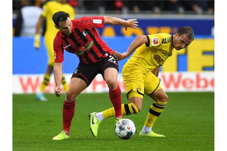 Freiburgs Nicolas Höfler (l), hier im Duell mit Mario Götze von Dortmund. Foto: Patrick Seeger/dpa