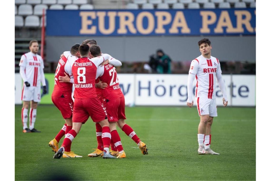 Schalke wendet Negativrekord ab - Leipzig verliert gegen BVB Freiburgs Spieler jubeln nach dem 1:0 - daneben die enttäuschten Kölner Spieler. Foto: Sebastian Gollnow/dpa