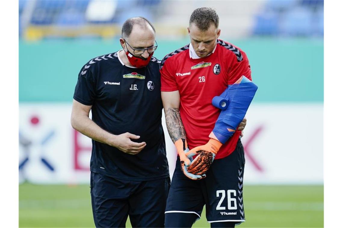Freiburgs Torwart Mark Flekken geht vor Spielbeginn verletzt vom Spielfeld. Foto: Uwe Anspach/dpa